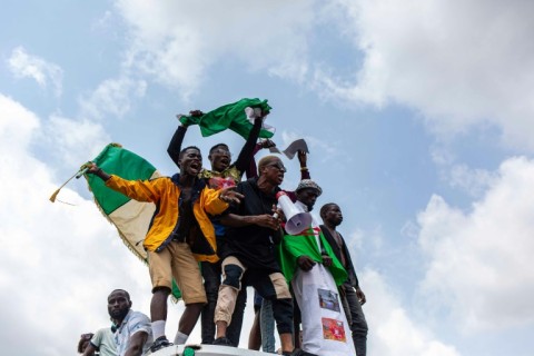 Nigerian youths seen waving the Nigerian national flag in front of a crowd in support of protests against police brutality and bad governance in Lagos on October 13, 2020.