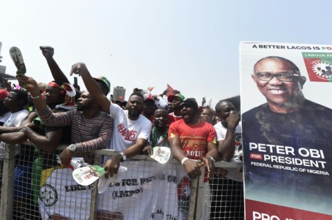 Supporters chant party slogans next to a banner of the candidate of the Labour Party Peter Obi during a campaign rally of the party in Lagos, on February 11, 2023.