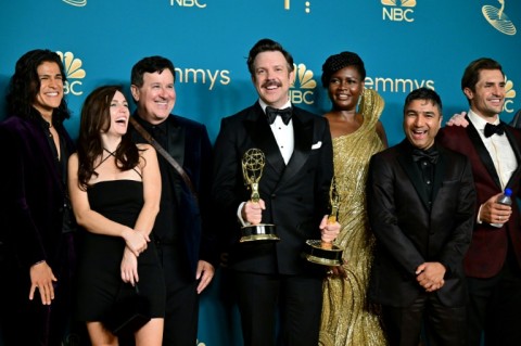 Actor Jason Sudeikis (C), surrounded by the cast and crew of 'Ted Lasso,' poses with their Emmy awards on September 12, 2022