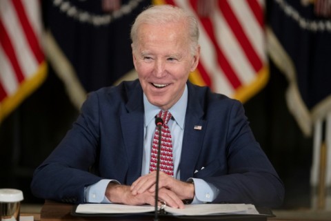 US President Joe Biden smiles at an event in the White House that overlapped with Donald Trump's arrest in New York