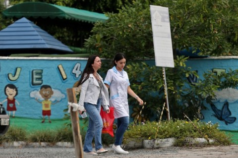 Women walk outside the preschool where an attacker killed four children in Blumenau in   southern Brazil