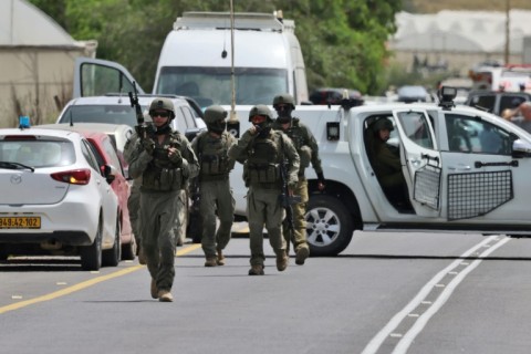 Israeli forces and emergency personnel gather near Hamra junction, in the occupied West Bank, following a shooting attack