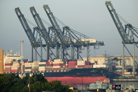 Shipping containers are seen stacked on a ship at port in Karachi on April 6, 2023. Pakistan has only enough forex reserves to pay for a month of imports