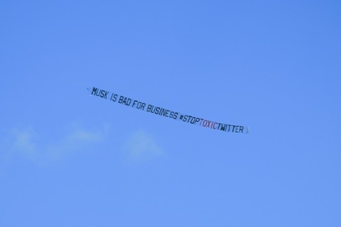 A banner reading, "Musk is Bad for Business #StopToxicTwitter" is flown over a conference venue in Miami, Florida where the Twitter CEO made a keynote address