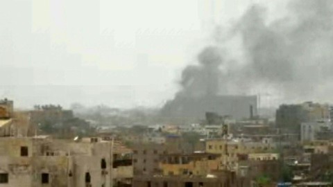 Smoke rises from a building next to a damaged car in Khartoum, in this photo released by Indonesia on April 24