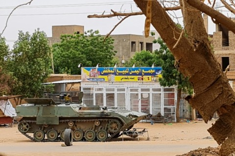 Sudanese Army soldiers rest beside an armoured vehicle at a checkpoint in Khartoum 