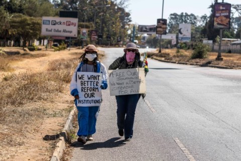 Dangarembga (L) and colleague Julie Barnes hold placards during their 2020 anti-corruption protest in Harare