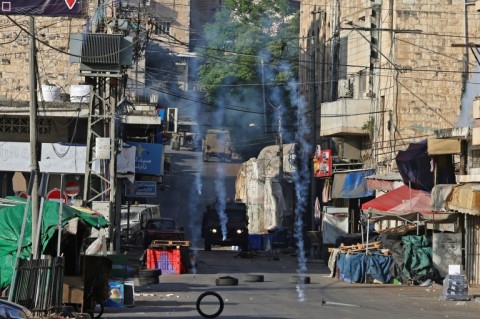 Israeli security forces fire tear gas to disperse Palestinians during a raid in the occupied West Bank city of Nablus