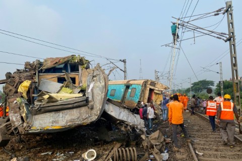 Rescue workers search for survivors at the accident site of a three-train collision near Balasore, India