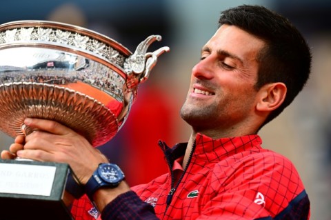 Record-breaker: Novak Djokovic poses with his trophy on Sunday