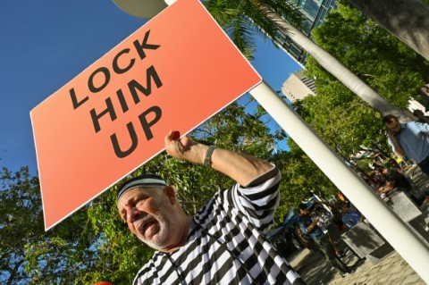 A protester holds a sign outside the Wilkie D. Ferguson Jr. United States Courthouse before the arraignment of former President Donald Trump in Miami, Florida