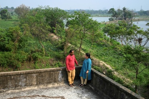 Environmental researcher Dhruba Das Gupta talks with fish farmer Sujit Mondal, who says pollution has hurt production