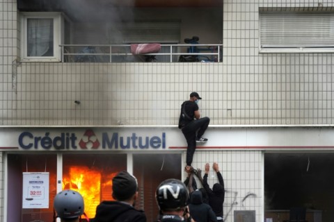 A protester climbs on a building during clashes in Nanterre on Thursday