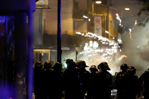 Fireworks explode as police stand by during protests in the northern city of Roubaix