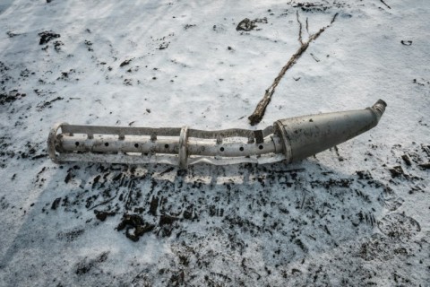 A casing of a cluster bomb rocket lays on the snow-covered ground in Zarichne, Ukraine