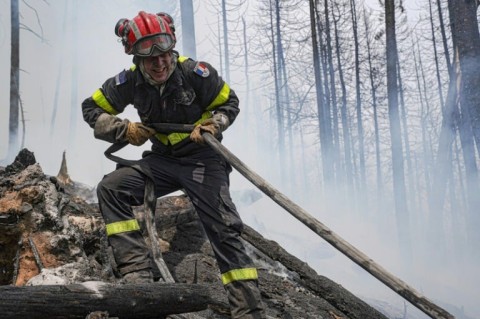 A French firefighter battles a blaze at Lac Larouche in Canada's Quebec Province in late June 