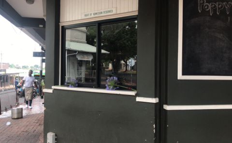 Flowers placed on a window sill at Poppy's restaurant in Melville following a deadly shooting.