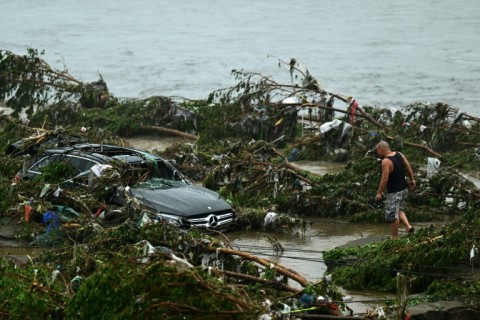 A man looks at a damaged car following heavy rains in Fangshan district in Beijing