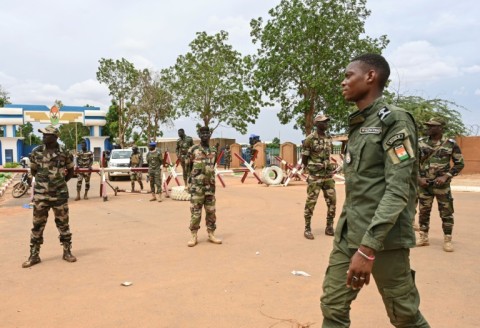 Nigerien soldiers stand guard as supporters of the coup rally