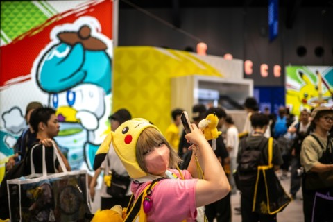 A Pokemon fan poses outside one of the merchandise booths at the weekend event in Yokohama