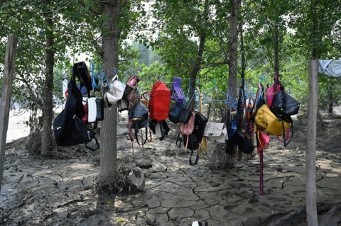 Handbags are hung to dry by a muddy street in the aftermath of flooding after heavy rains in Zhuozhou city, in northern China's Hebei province