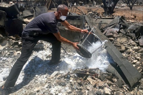 Anthony La Puente, 44, recovers items from his house that was burned in a wildfire in Lahaina, Hawaii