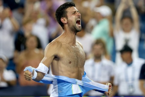 Novak Djokovic of Serbia tears his shirt in celebration after beating Carlos Alcaraz in the final of the ATP Cincinnati Open