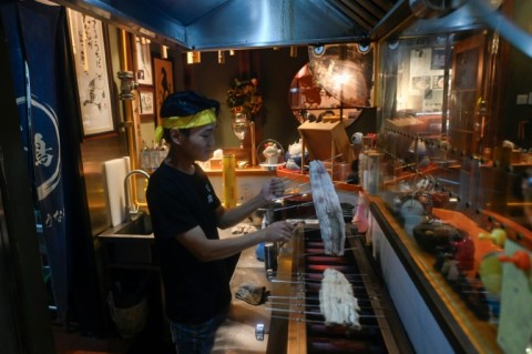 A worker cooks an eel in a Japanese restaurant in Beijing 