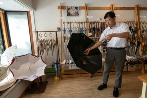 Hiroyuki Komiya shows off umbrellas at Komiya Shoten, a company his grandfather founded 93 years ago