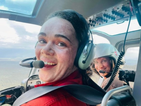 This handout photo dated July 13, 2022, shows firefighter Kara Galbraith (L), in a helicopter Carmacks, Yukon, Canada, flying to a fire. Galbraith was deployed with an Initial Attack Crew to help with the fires in the Yukon