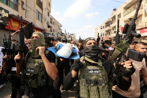 Palestinian militants carry the body of 19-year-old Ahmad Awawda who was killed in clashes with Israeli troops in the occupied West Bank region of Nablus the previous day, during his funeral in Jenin on October 8, 2023