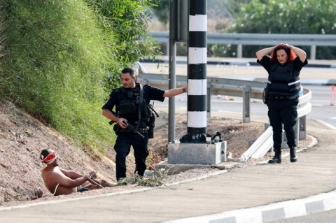 Israeli security forces guard a captured Palestinian prisoner near the southern Israeli city of Ashkelon on the border with Gaza on October 8, 2023