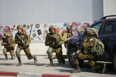 Israeli soldiers deploy in an area where civilians were killed in the southern city of Sderot 