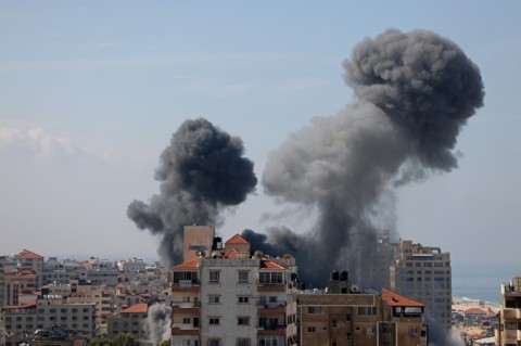 Palestinians curround a reportedly captured and injured Israeli man, in Khan Yunis in the southern Gaza Strip, on October 7, 2023