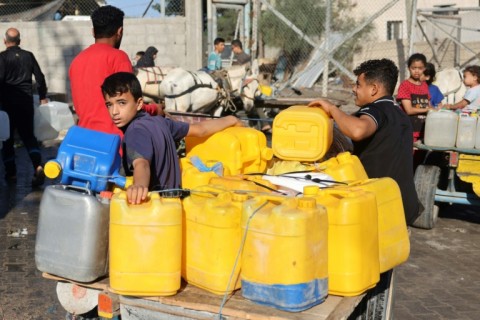 Palestinains ride a donkey cart carrying water, in Khan Yunis, in the southern Gaza Strip on October 26, 2023