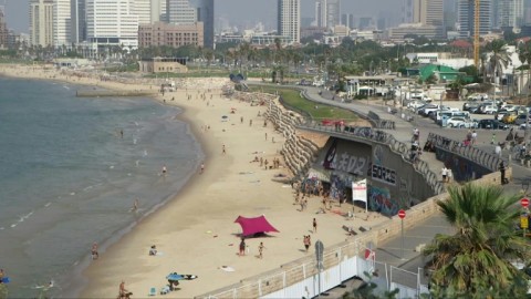 Beachgoers run to take shelter as sirens wail in Tel Aviv