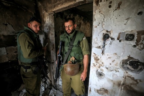 Israeli soldiers enter a home in Kfar Aza, one of the kibbutzim attacked by Palestinian Hamas militants on October 7