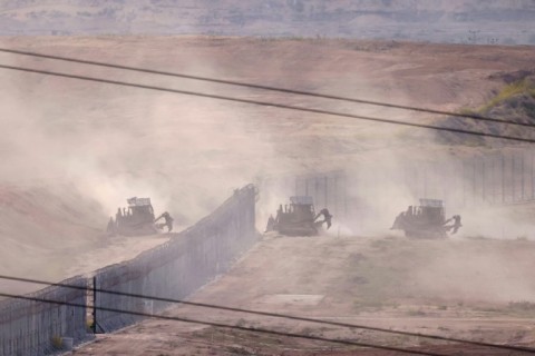 Israeli military armoured bulldozers cross into Gaza on October 29, 2023 