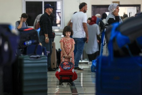 Civilians fleeing Gaza wait as dual national Palestinians and foreigners prepare to cross the Rafah border point with Egypt, in the southern Gaza Strip, on November 2, 2023