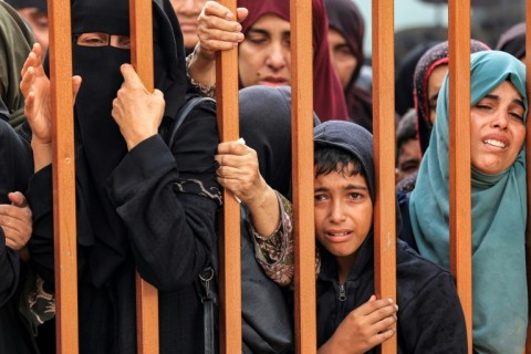 Mourners stand near the bodies of the dead in southern Gaza