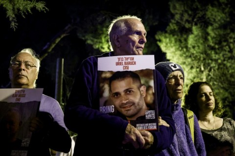 A man in Israel holds a portrait of a hostage Hamas militants