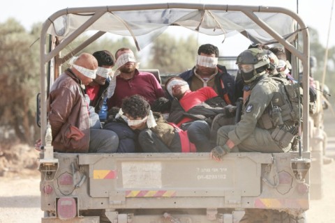 Israel soldiers transfer detained Palestinians out of the Gaza Strip on November 21, 2023