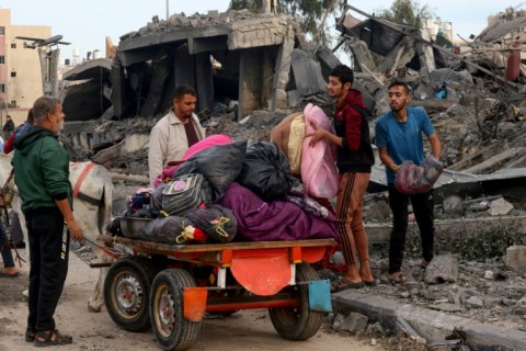 A man carries the body of a child during the funeral of members of a family killed in a strike in Khan Yunis in the southern Gaza Strip on November 22, 2023