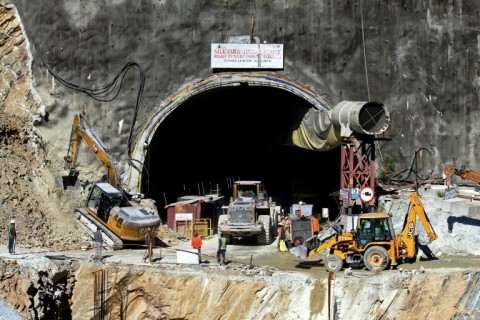 Rescue workers stand at an entrance of the under-construction road tunnel, days after it collapsed  