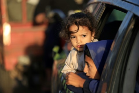 Children look out of a car window in the Gaza Strip as Palestinians head home during a pause in fighting between Israel and Hamas