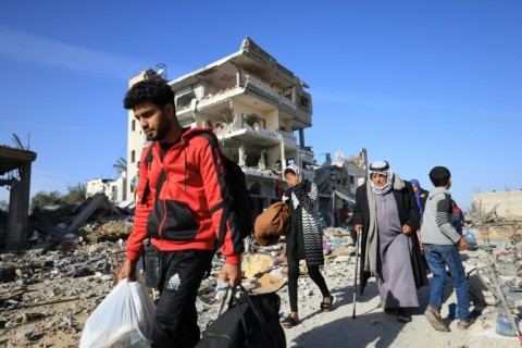 Palestinians who had taken refuge in temporary shelters head home during a pause in fighting in the Gaza Strip