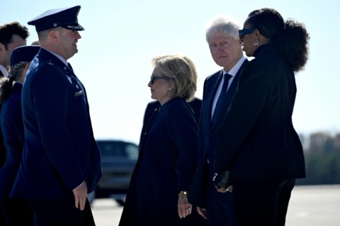 Former US Secretary of State Hillary Clinton, former US President Bill Clinton, and former US First Lady Michelle Obama are greeted upon arrival at Dobbins Air Reserve Base as they arrive to attend a tribute service for former US First Lady Rosalyn Carter