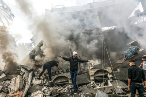 Palestinians react amid the rubble of destroyed buildings in Rafah