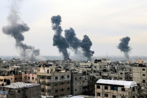 A picture taken on December 20, 2023, from Rafah shows smoke billowing after Israeli strikes over the Nuseirat refugee camp in the central Gaza Strip