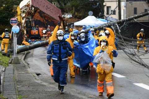 Rescuers carry away the body of a landslide victim